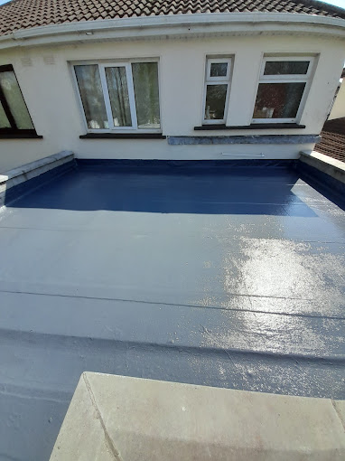 image of a Dublin roofer looking down on a slate roof being repaired.